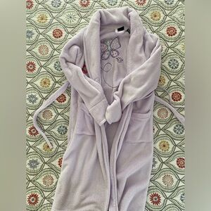 Purple Kids bathrobe with butterfly on back and flower growing in pocket